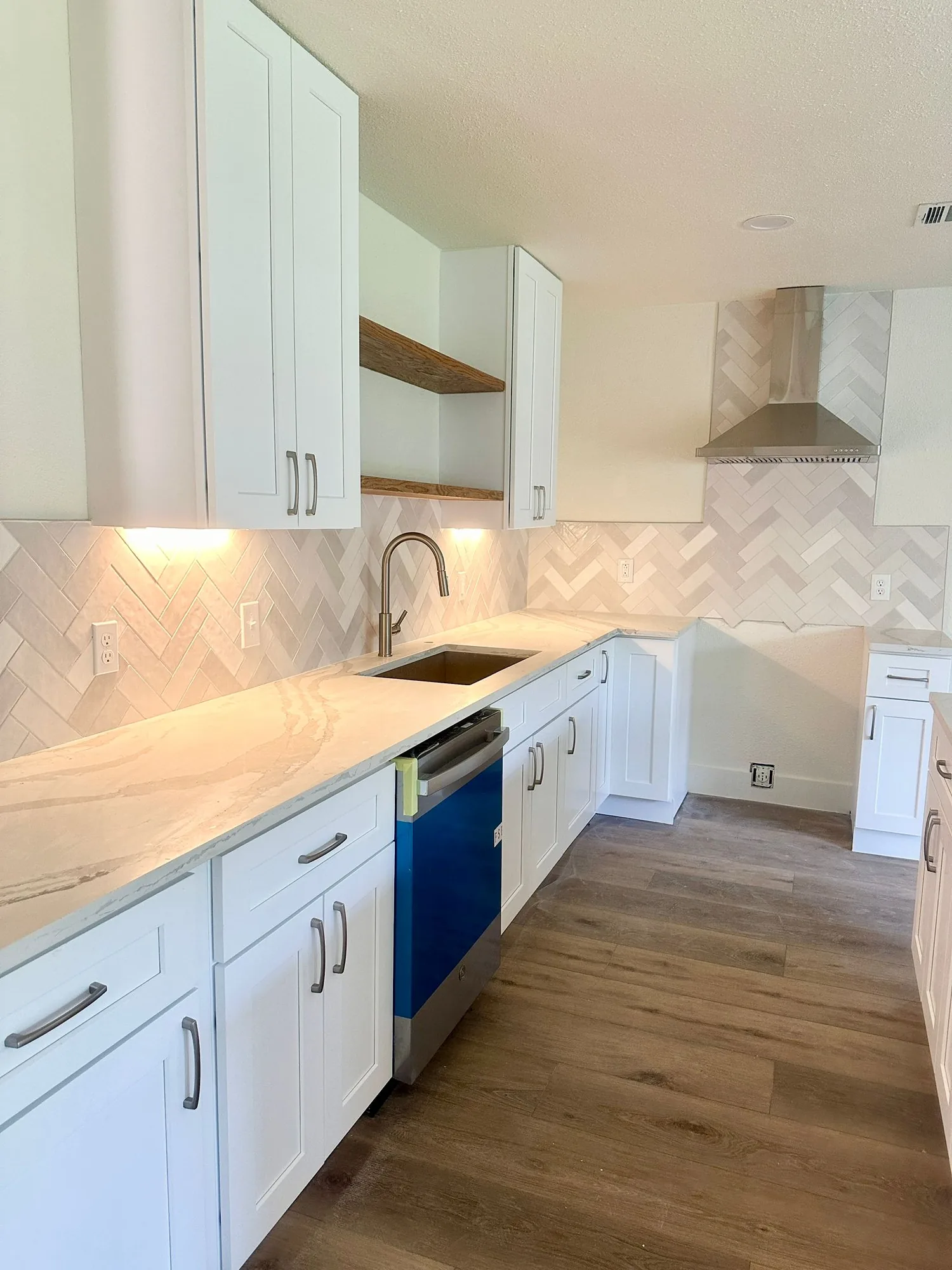 White shaker kitchen with herringbone tile backsplash