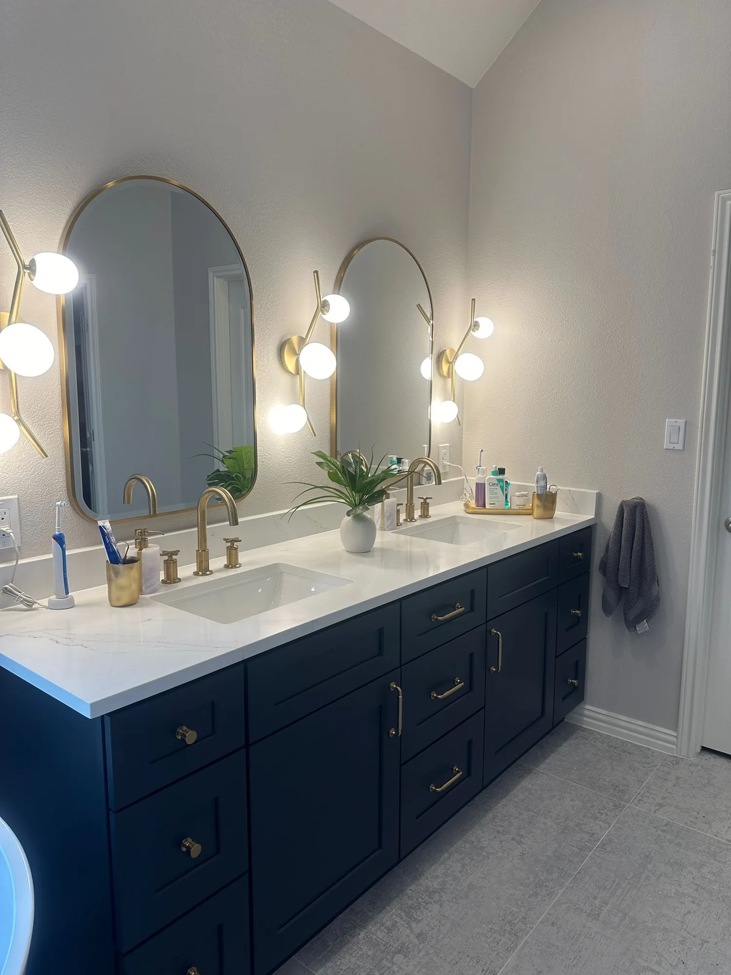 Navy double vanity with brass hardware and arched mirrors