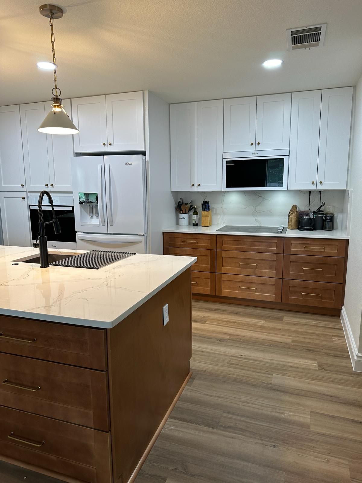 Kitchen with white upper cabinets and warm maple lowers