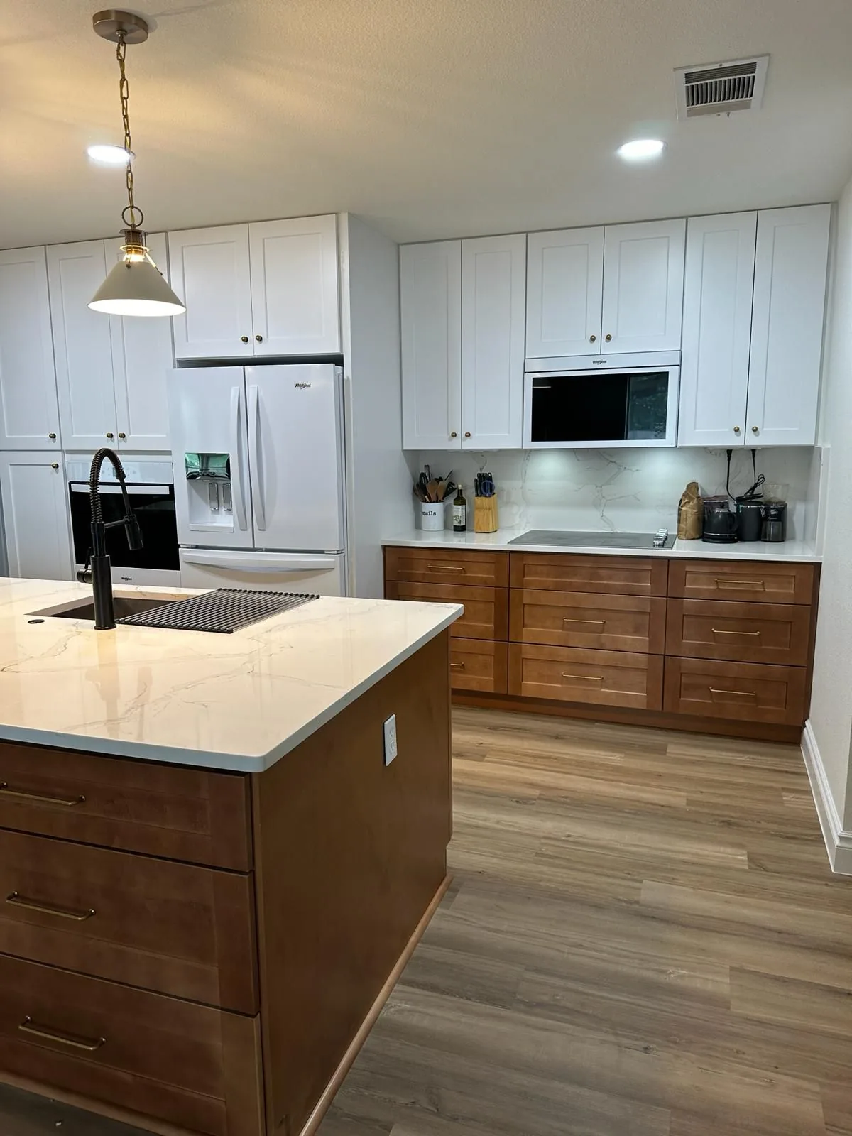 Kitchen with white upper cabinets and warm maple lowers
